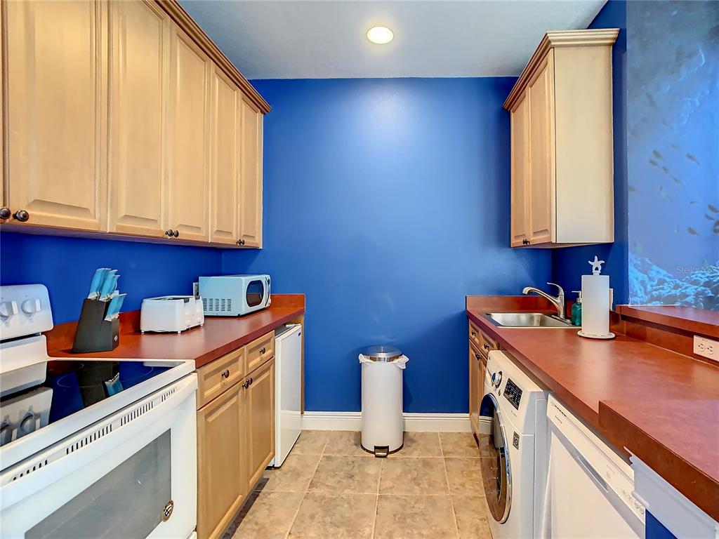 1424 Titian Court Reunion, FL 34747 - Photo 44 of 63 a kitchen with stainless steel appliances a sink a stove and a refrigerator