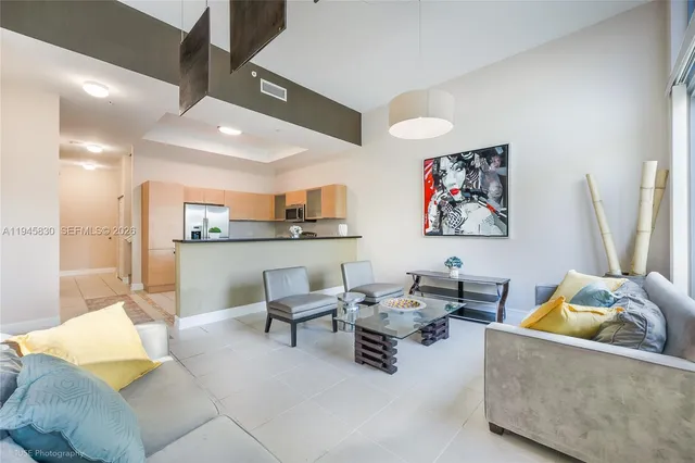 a living room with furniture and a dining table with kitchen view