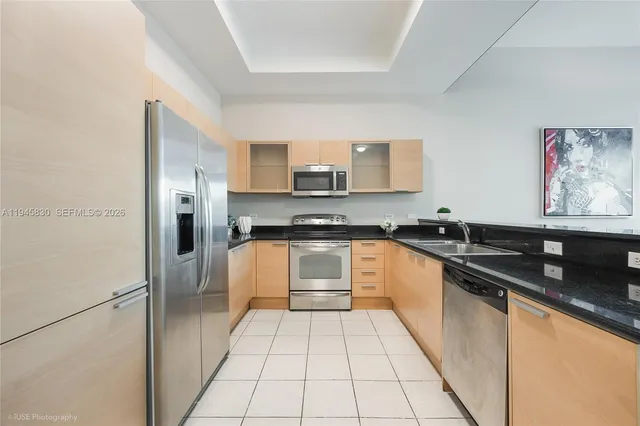 a kitchen with stainless steel appliances granite countertop a stove a sink and a refrigerator