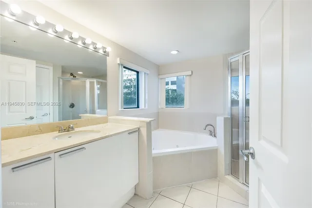 a bathroom with a tub a sink and a mirror