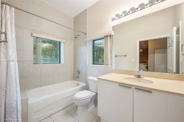 a bathroom with a sink a toilet a mirror and bathtub