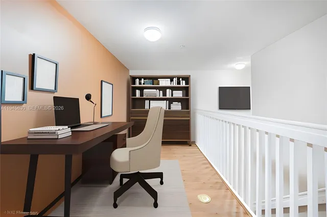 a view of a workspace with furniture and wooden floor