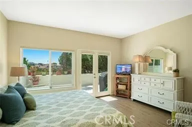 a spacious bedroom with a bed and wooden floor