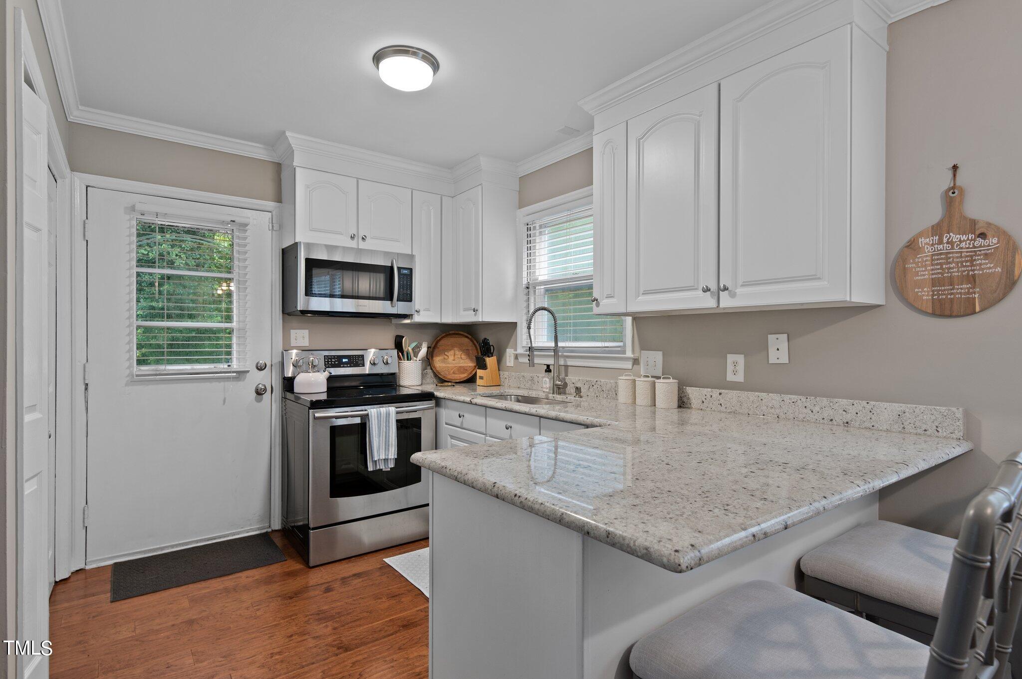 801 Purdue Street Raleigh, NC 27609 - Photo 13 of 40 a kitchen with granite countertop stainless steel appliances a stove a sink a microwave and cabinets