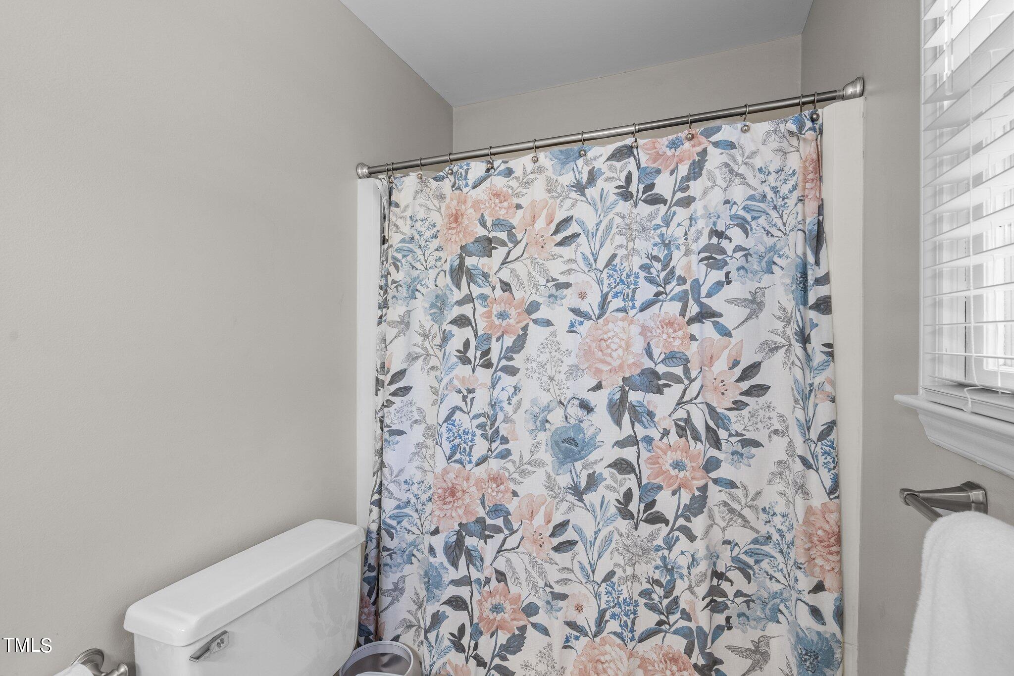 801 Purdue Street Raleigh, NC 27609 - Photo 21 of 40 a white toilet sitting next to a shower curtain