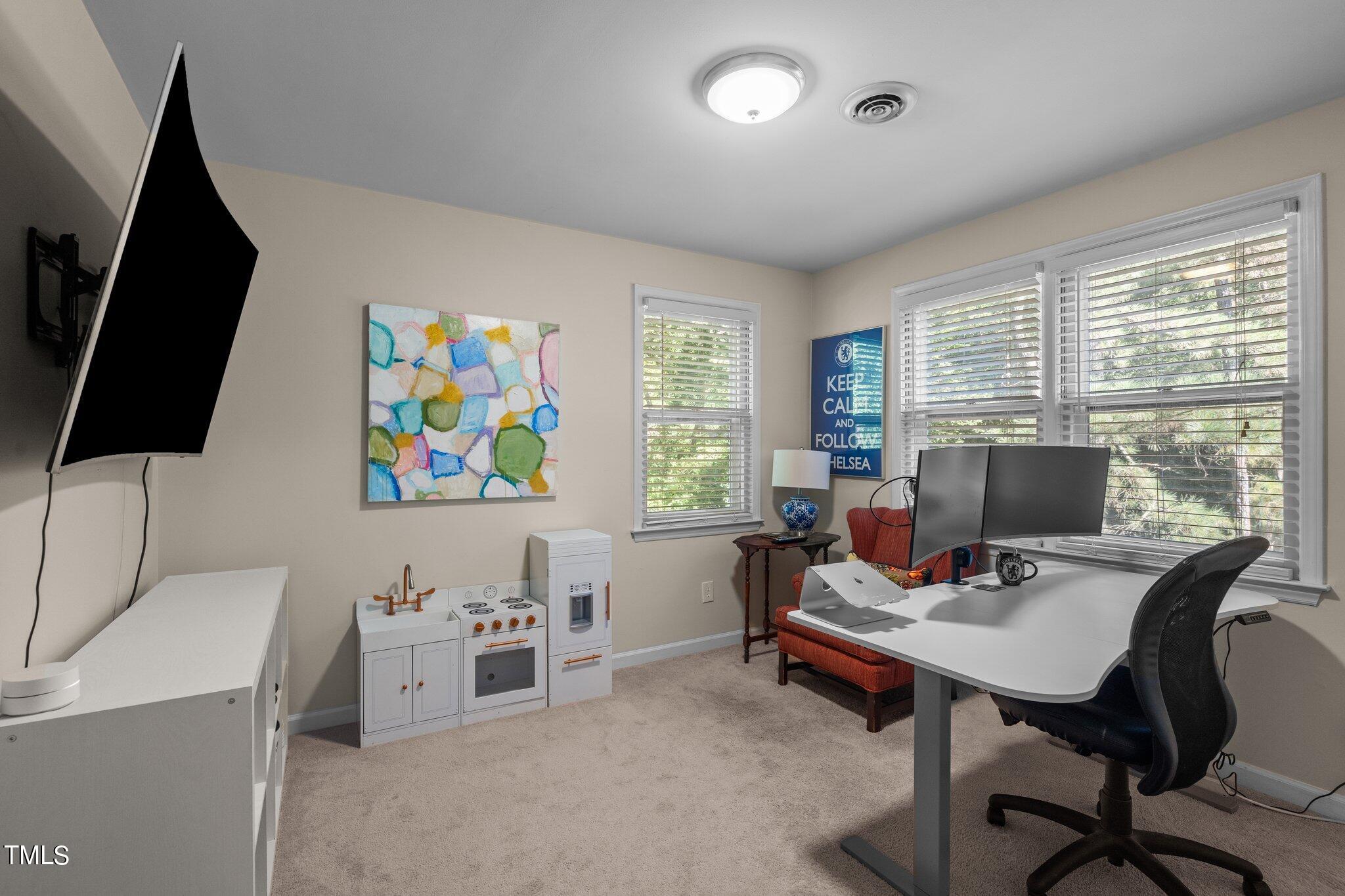 801 Purdue Street Raleigh, NC 27609 - Photo 24 of 40 a workspace with furniture and a flat screen tv