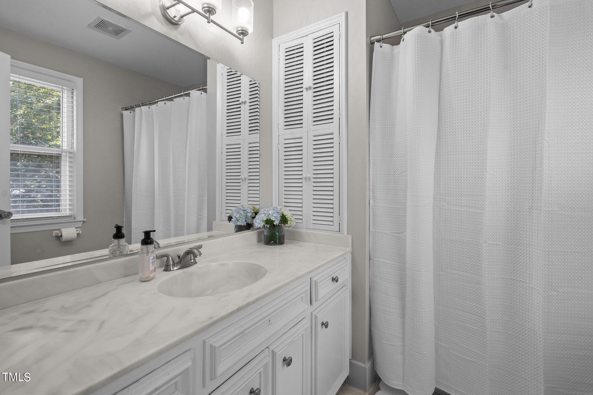 801 Purdue Street Raleigh, NC 27609 - Photo 29 of 40 a bathroom with a granite countertop sink and a mirror