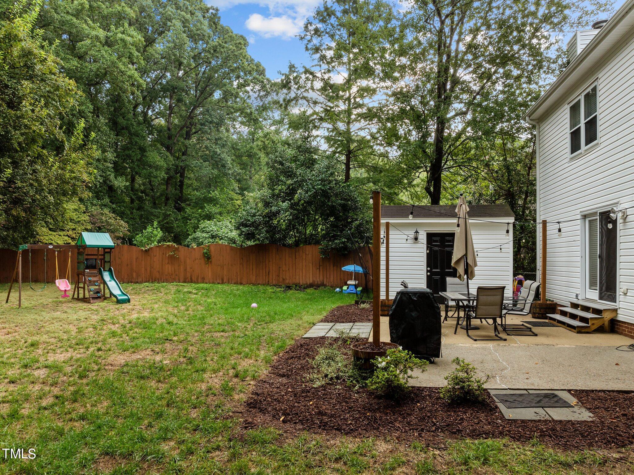 801 Purdue Street Raleigh, NC 27609 - Photo 31 of 40 a view of a backyard with sitting area and slide