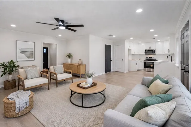 a view of an empty room with kitchen appliances and a ceiling fan