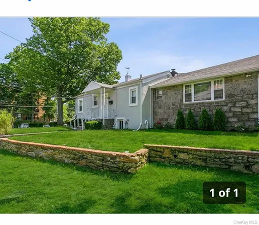 a view of a big house with a big yard and large trees