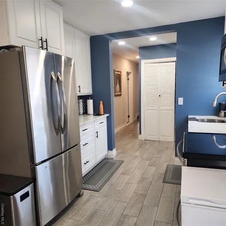 a kitchen with stainless steel appliances a refrigerator sink and cabinets