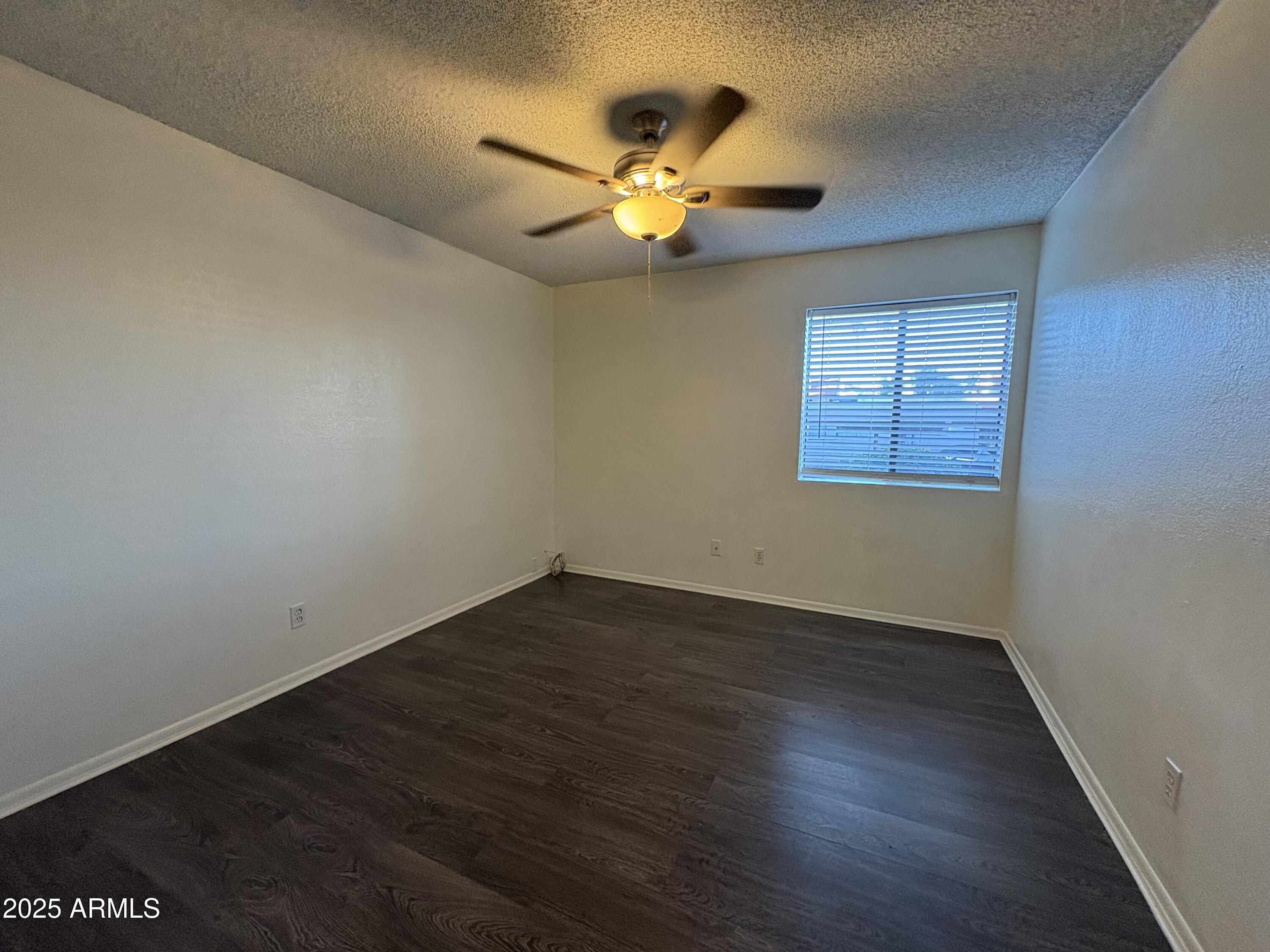 2938 North 61st Place, Unit 150 Scottsdale, AZ 85251 - Photo 15 of 24 an empty room with wooden floor fan and windows