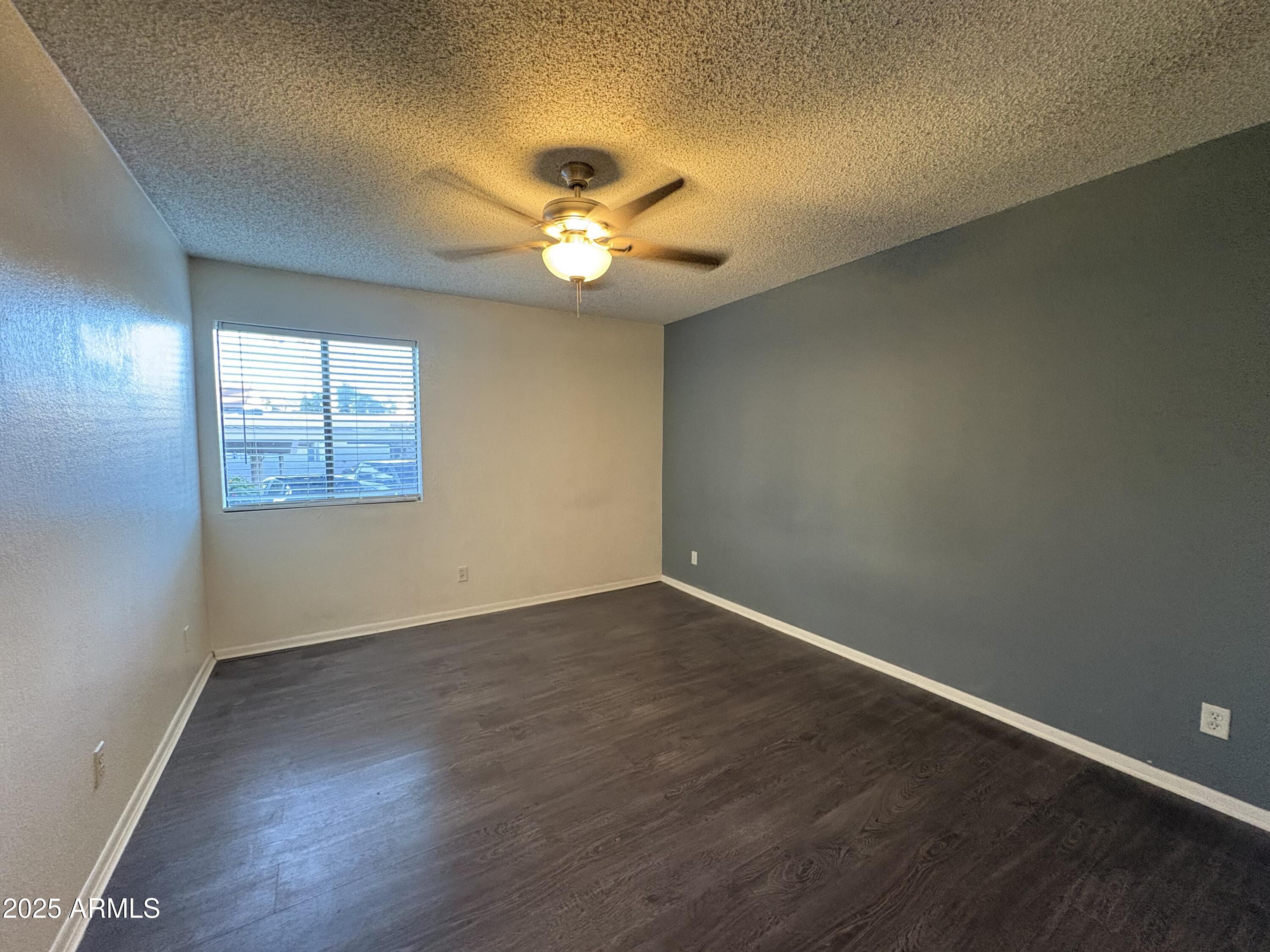 2938 North 61st Place, Unit 150 Scottsdale, AZ 85251 - Photo 16 of 24 an empty room with wooden floor and windows