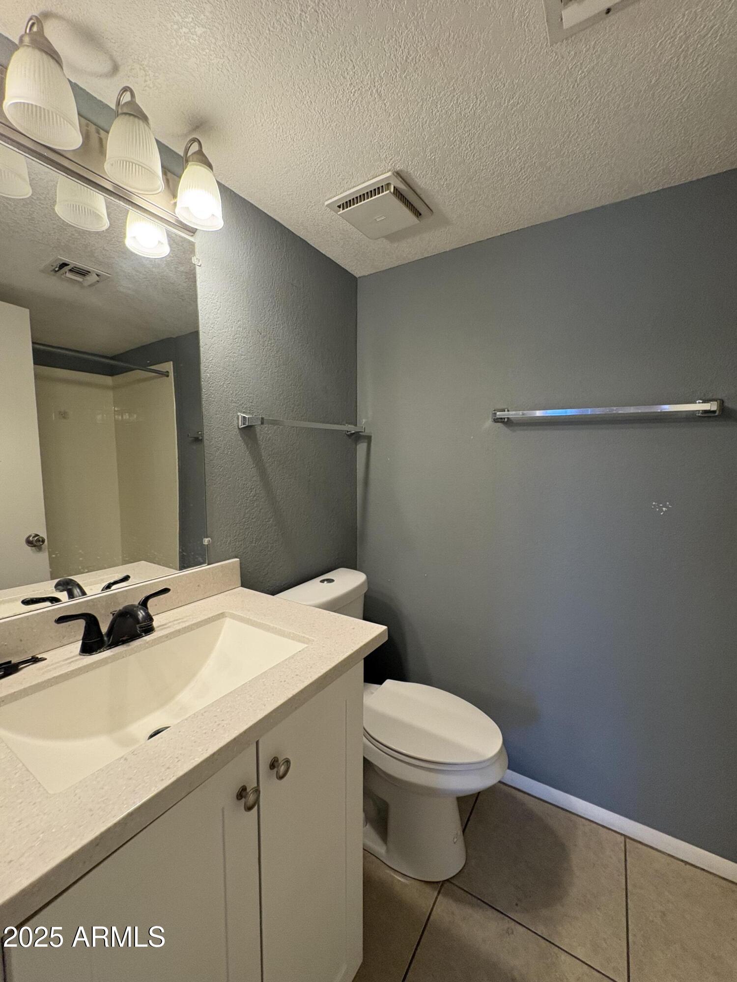 2938 North 61st Place, Unit 150 Scottsdale, AZ 85251 - Photo 17 of 24 a bathroom with a sink a toilet a mirror and vanity