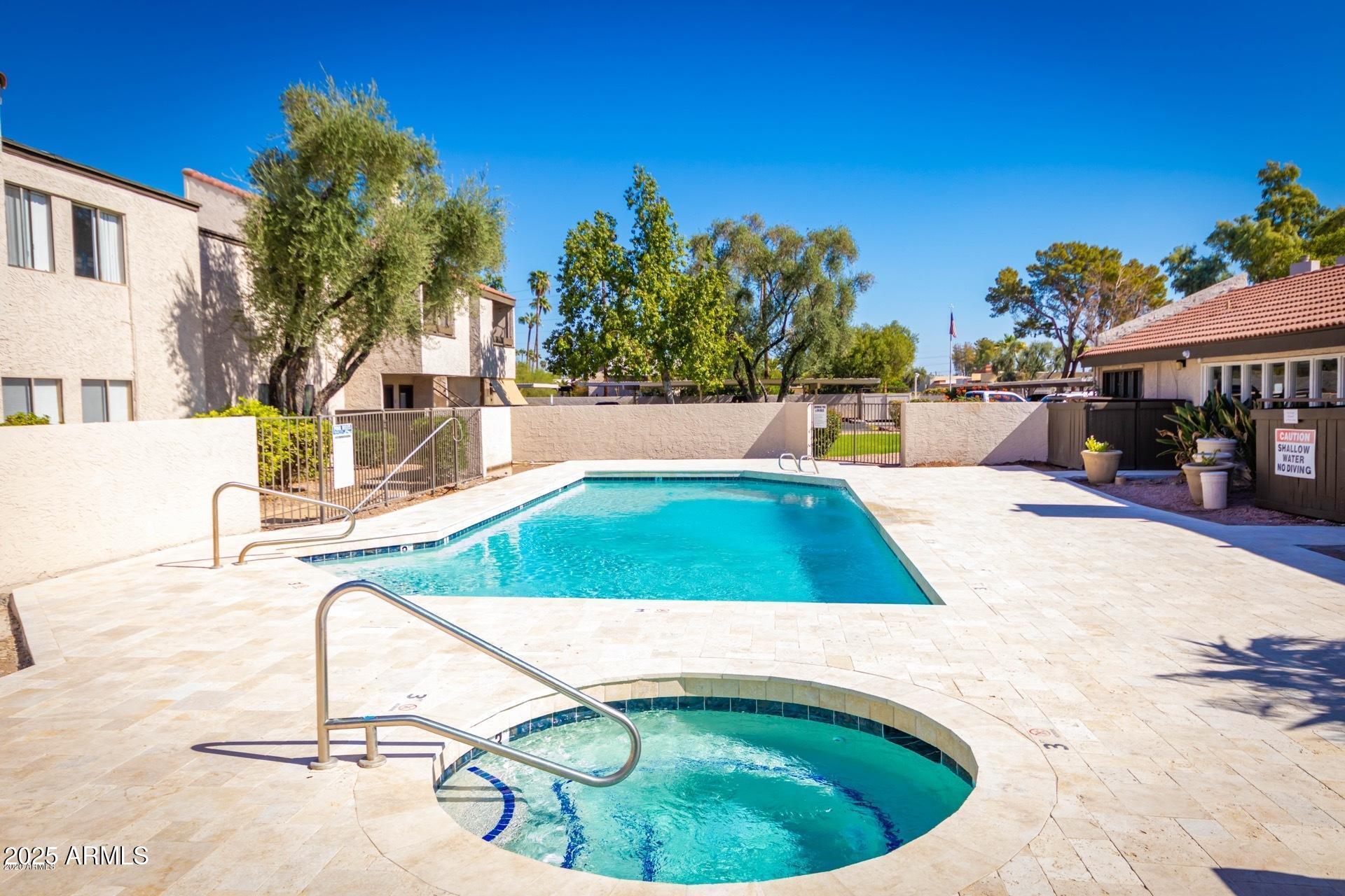 2938 North 61st Place, Unit 150 Scottsdale, AZ 85251 - Photo 20 of 24 a view of a swimming pool with a lounge chairs