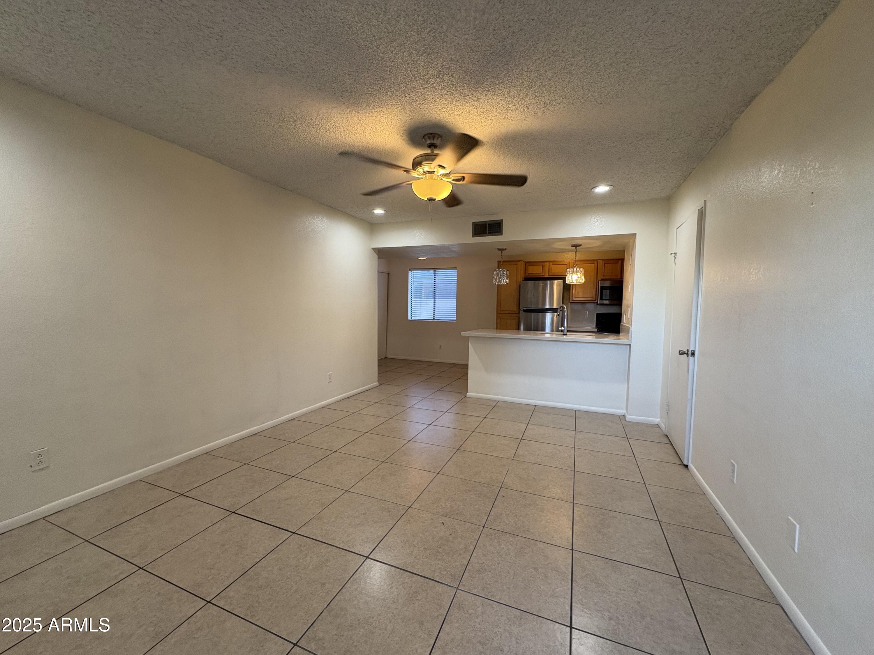 2938 North 61st Place, Unit 150 Scottsdale, AZ 85251 - Photo 5 of 24 a view of an empty room and a ceiling fan