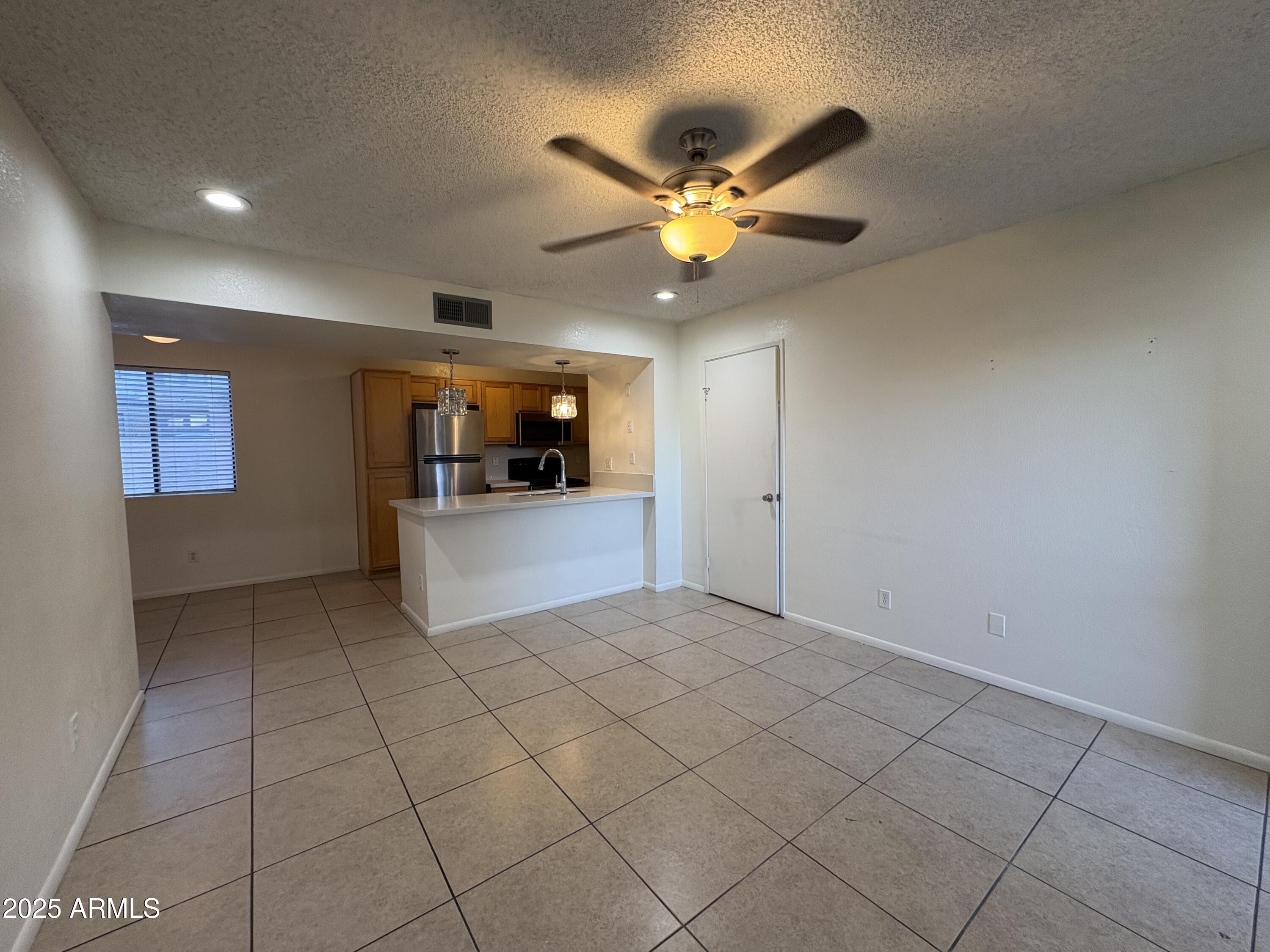 2938 North 61st Place, Unit 150 Scottsdale, AZ 85251 - Photo 7 of 24 a view of a kitchen with a sink and a chandelier fan