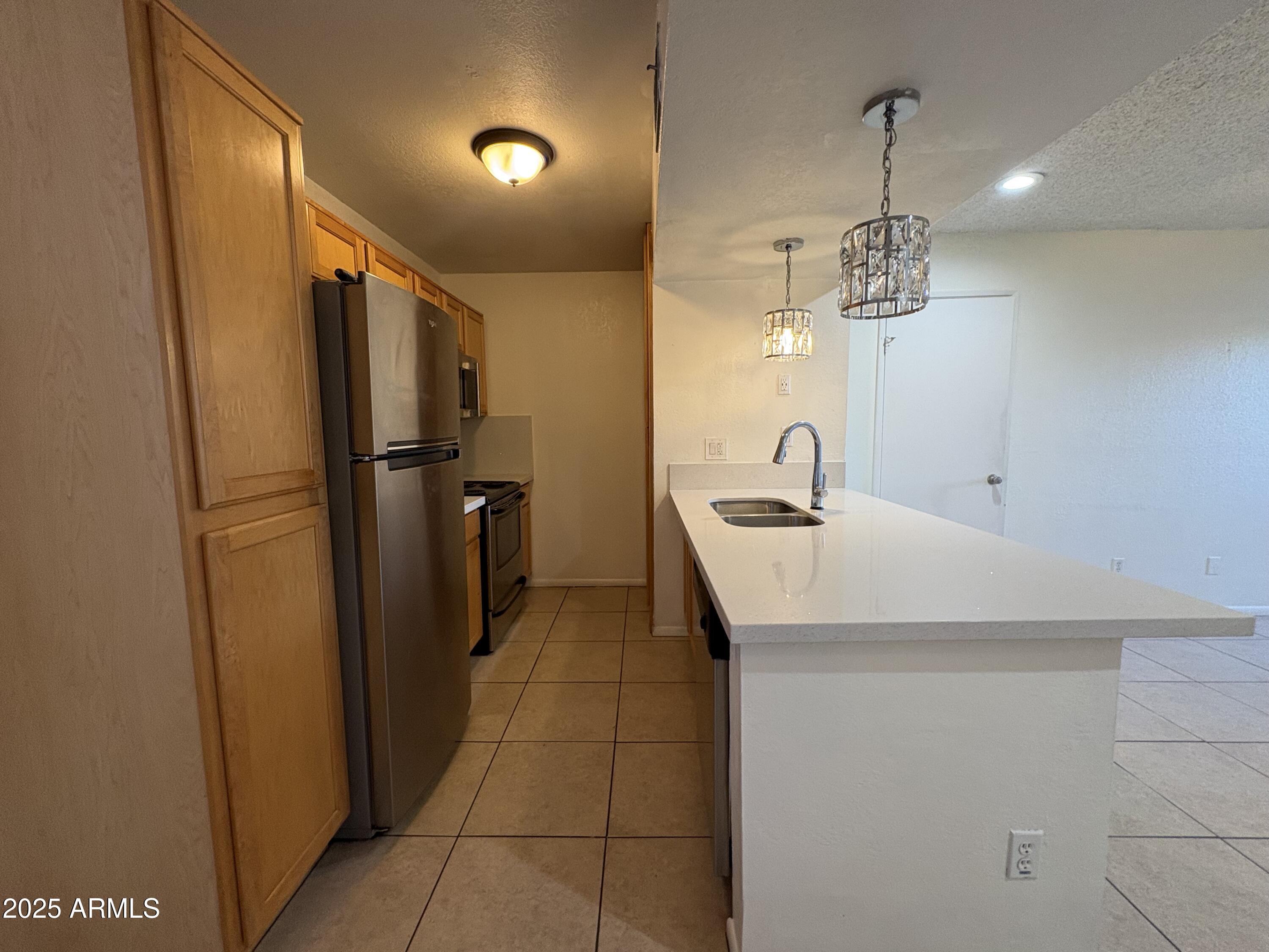 2938 North 61st Place, Unit 150 Scottsdale, AZ 85251 - Photo 9 of 24 a kitchen with stainless steel appliances a refrigerator and a sink