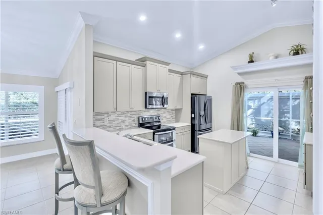 a kitchen with stainless steel appliances a table and chairs in it