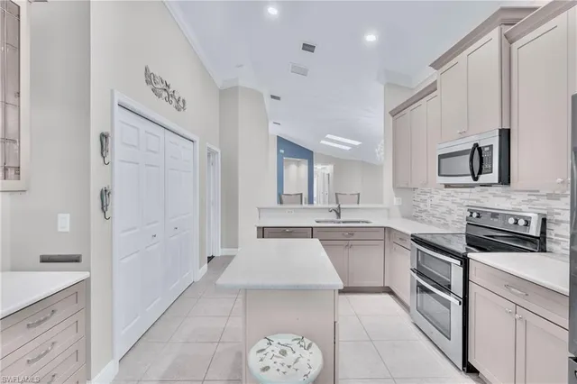 a large white kitchen with a stove a sink dishwasher and a refrigerator with wooden floor