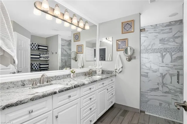 a bathroom with a granite countertop sink mirror and a shower