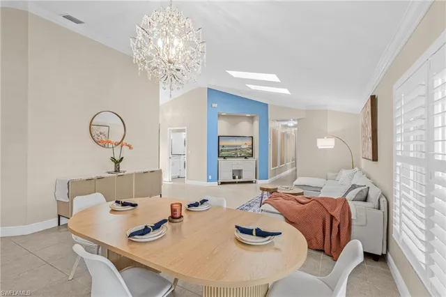 a living room with furniture a chandelier and a table
