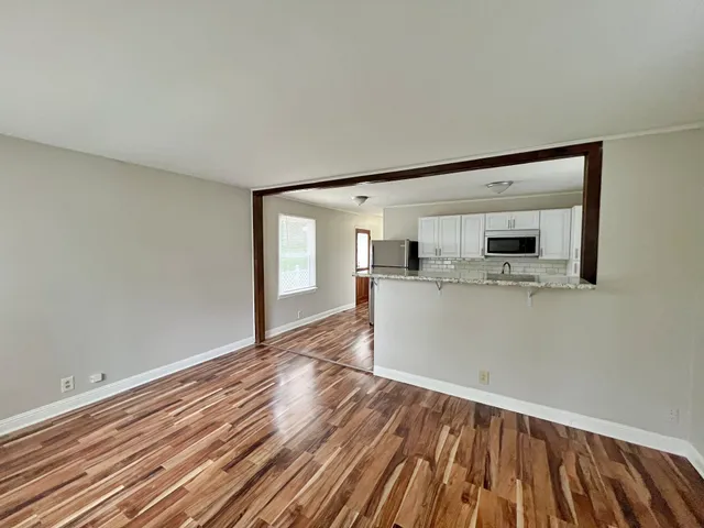 a view of a kitchen with wooden floor and a sink