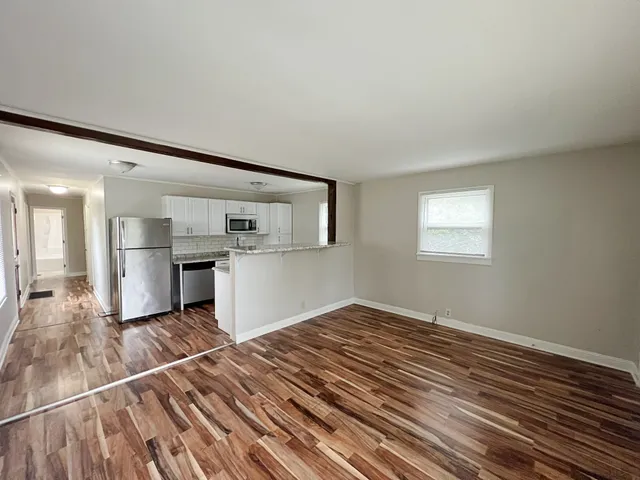 a view of a kitchen with wooden floor and a kitchen