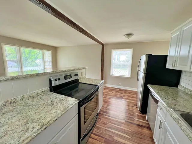 a kitchen with granite countertop sink stove and refrigerator
