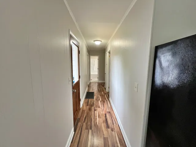 a view of a hallway with wooden floor