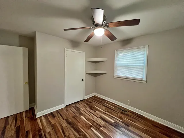 a view of a room with wooden floor and fan