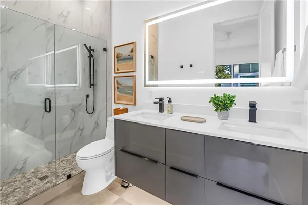 a spacious bedroom with a bed a couch and a flat screen tv