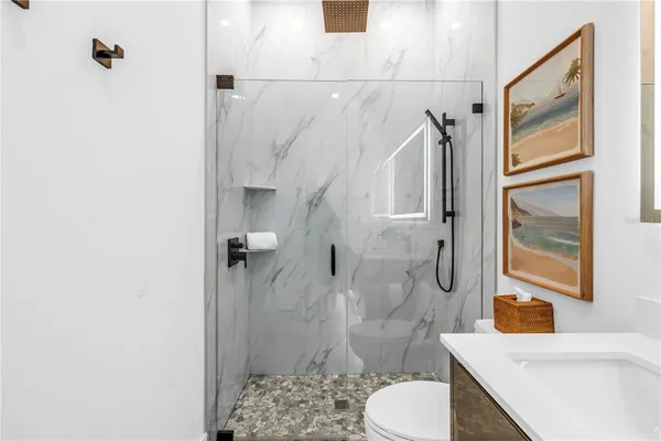 a bathroom with a sink a toilet and shower