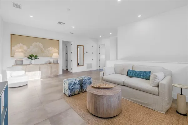 a living room with furniture a floor to ceiling window and a flat screen tv