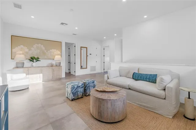 a living room with furniture a floor to ceiling window and a flat screen tv