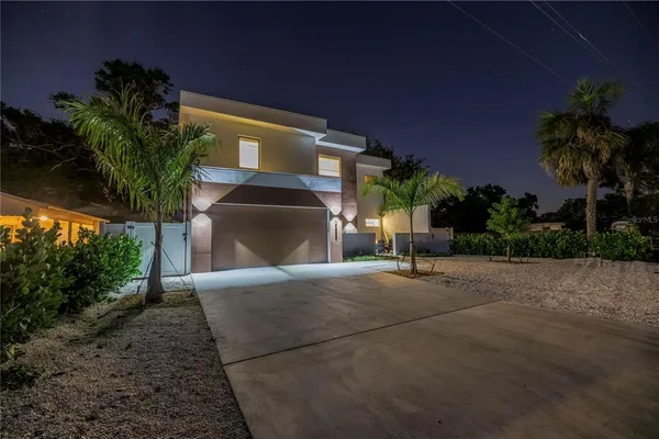 a kitchen with stainless steel appliances granite countertop a dining table chairs and white cabinets