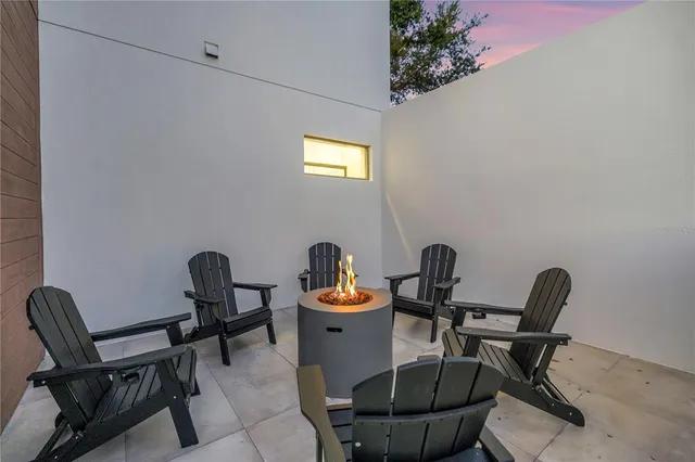a kitchen with stainless steel appliances kitchen island granite countertop a table chairs and a refrigerator