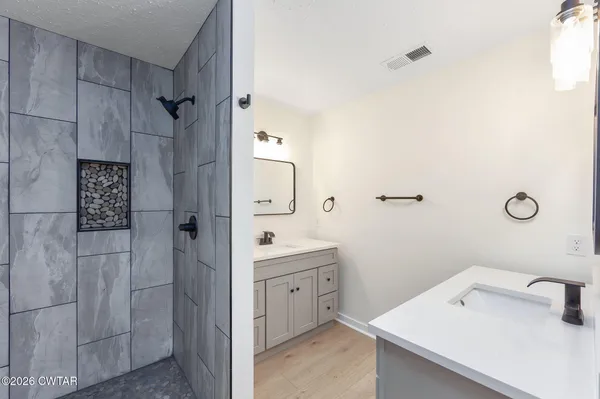 a bathroom with a sink a toilet and shower