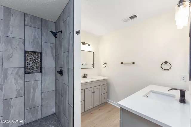 a bathroom with a sink a toilet and shower