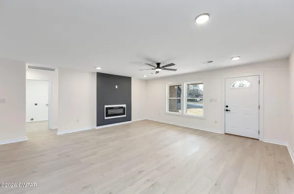 an empty room with windows and cabinet
