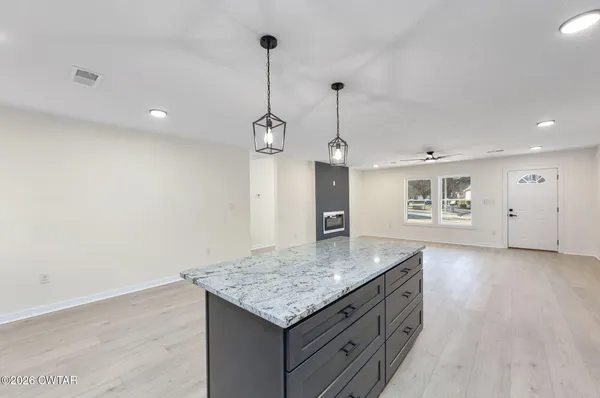 a kitchen with stainless steel appliances granite countertop a sink a refrigerator and wooden floor