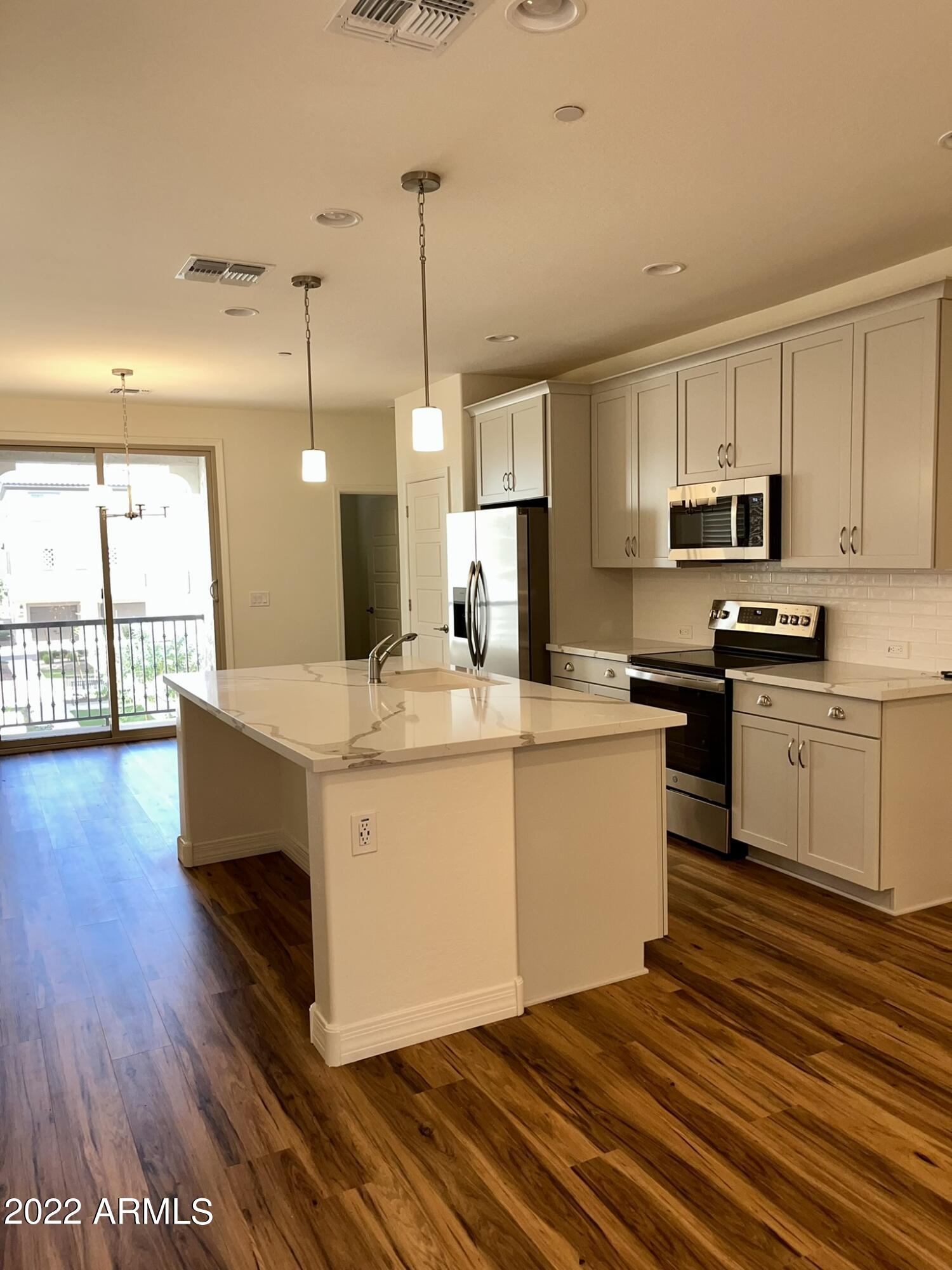 1737 East Hampton Lane Gilbert, AZ 85295 - Photo 11 of 15 a large kitchen with kitchen island a white counter space a sink and appliances