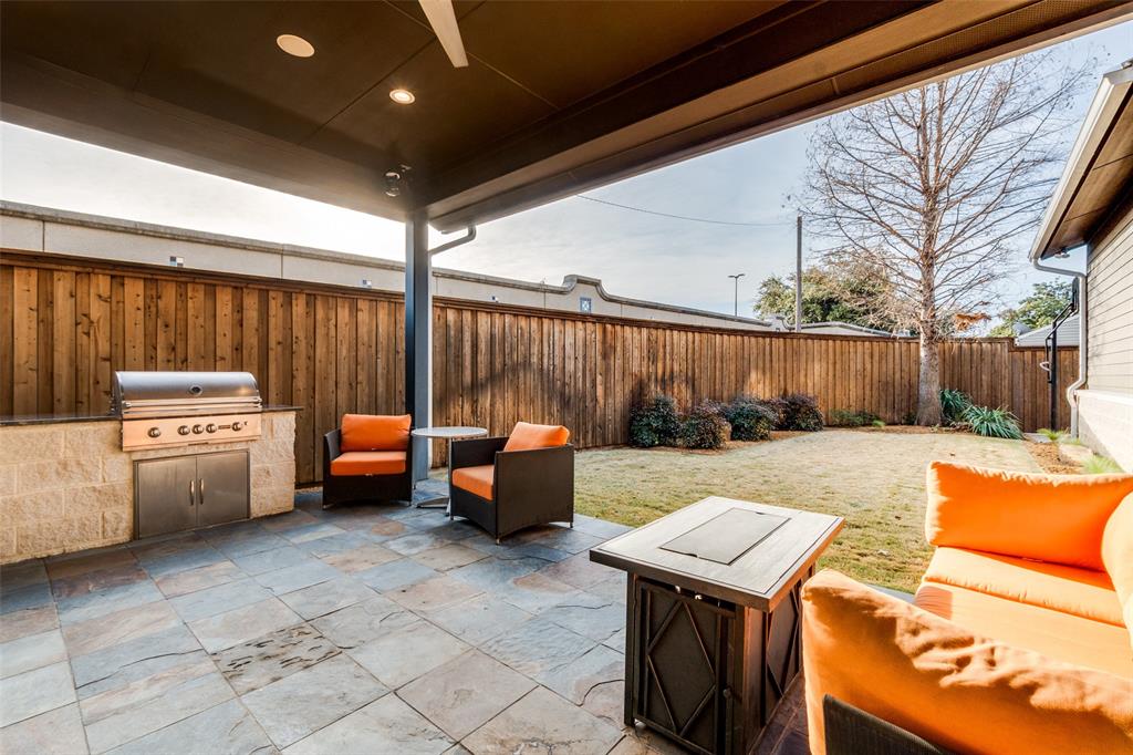 7912 Hanover Street Dallas, TX 75225 - Photo 6 of 29 Covered outdoor patio featuring stone tile flooring and a built-in grill station with stainless steel appliances