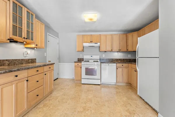 a kitchen with granite countertop white cabinets and white stainless steel appliances