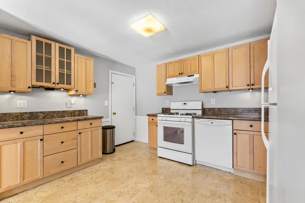 a kitchen with granite countertop a sink cabinets stainless steel appliances and a window
