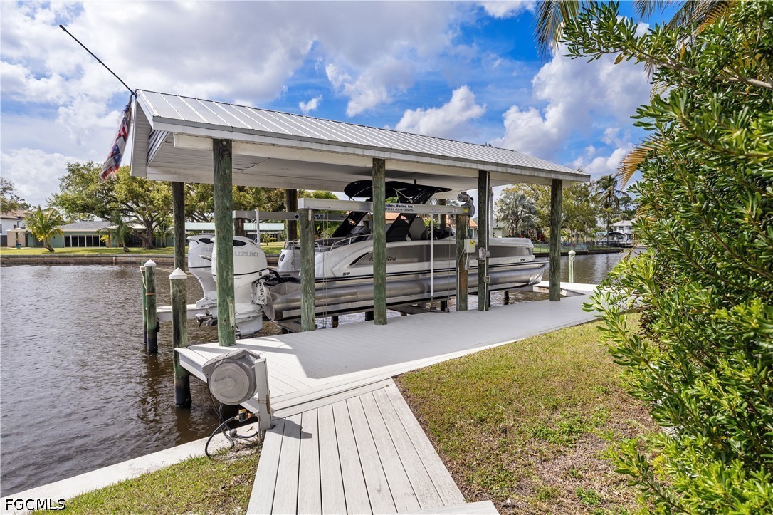 416 Seaworthy Road North Fort Myers, FL 33903 - Photo 27 of 30 a view of a patio with a dining table and chairs with wooden floor and fence