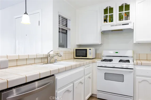 a kitchen with cabinets appliances and a sink