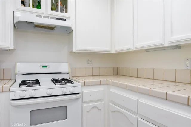 a kitchen with white cabinets and appliances