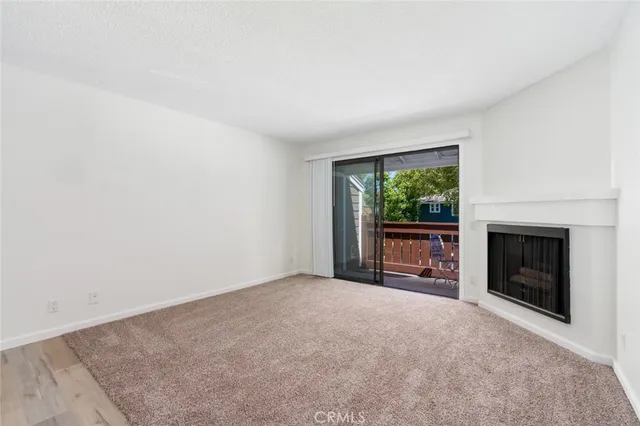 a view of an empty room with a window and fireplace