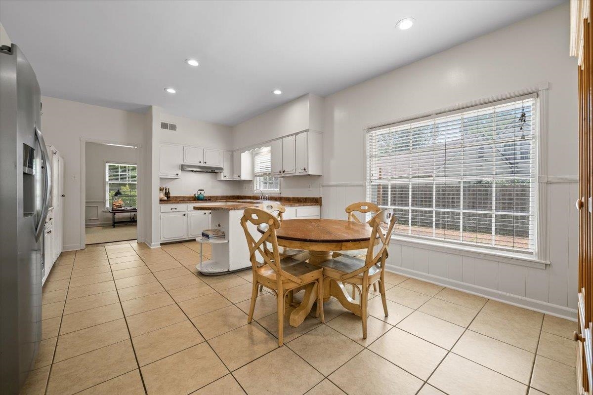 1273 Brookfield Road Memphis, TN 38119 - Photo 18 of 40 Kitchen featuring tile flooring, white cabinetry, a built-in kitchen island with a countertop extension, and a large window with horizontal blinds